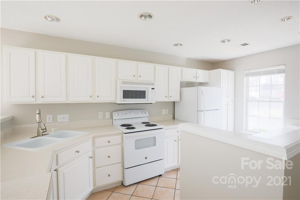 10328 Flat Stone Road Charlotte, NC 28213 - Photo 4 of 14 a kitchen with white cabinets and white appliances