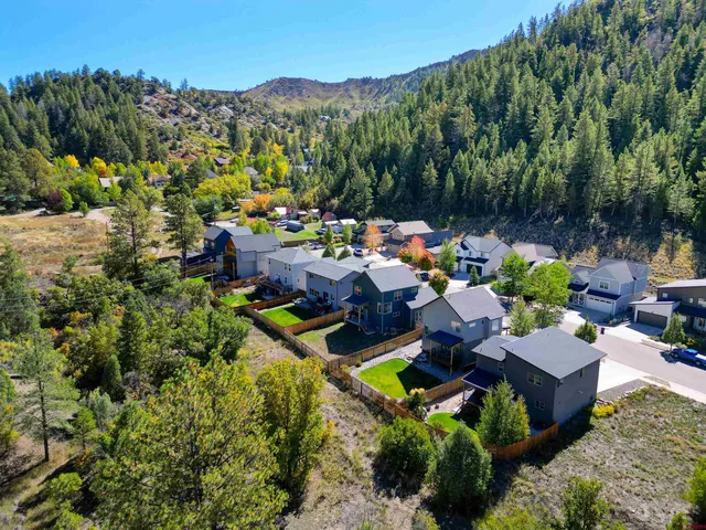 an aerial view of a house with swimming pool and a yard