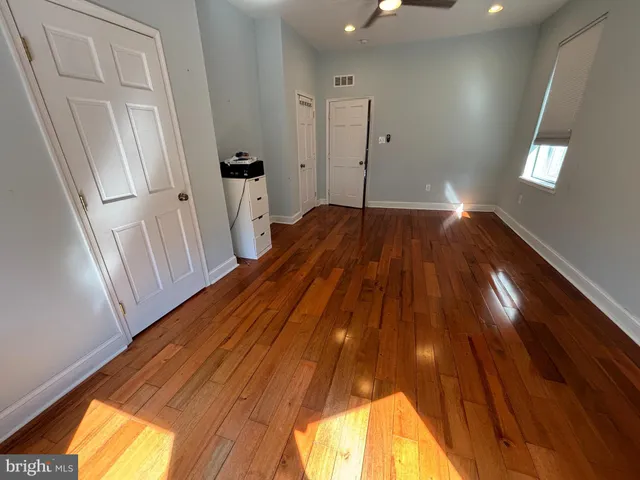 a view of empty room with wooden floor