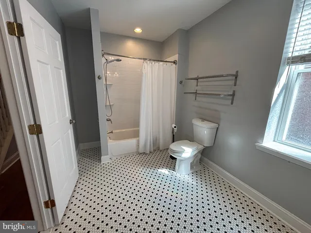 a bathroom with a toilet and a shower