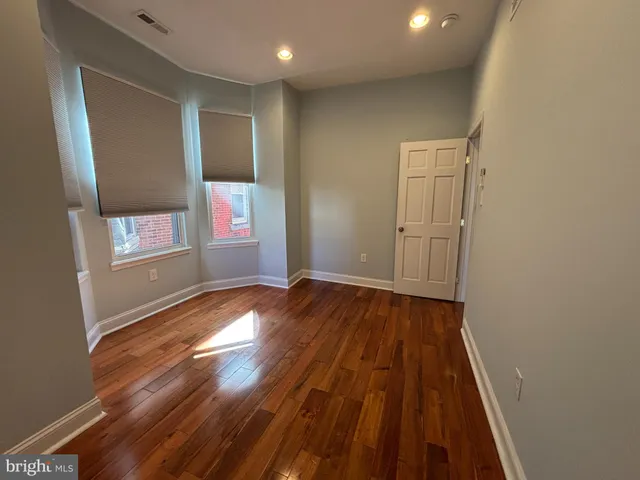a view of empty room with wooden floor