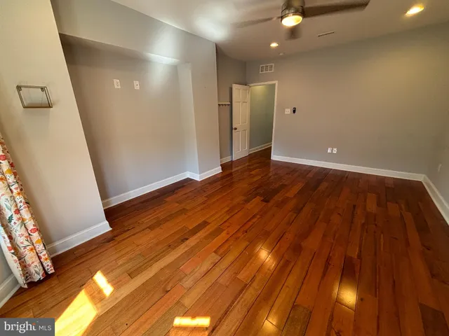 a view of a livingroom with wooden floor and staircase