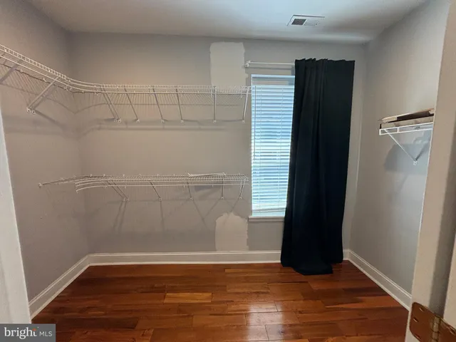 an empty room with wooden floor and cabinet