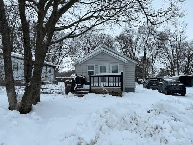 a view of a house with a yard covered in snow