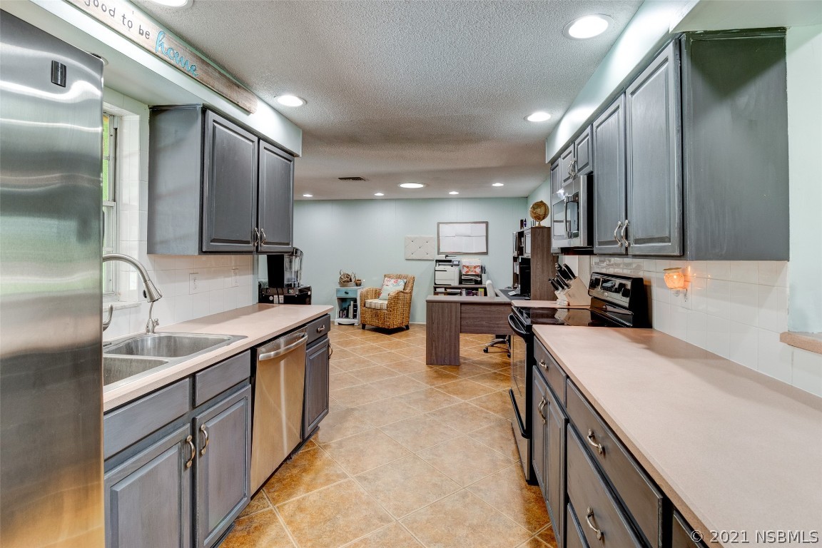 134 Arbor Lane Edgewater, FL 32141 - Photo 17 of 36 a kitchen with stainless steel appliances granite countertop a sink stove and refrigerator