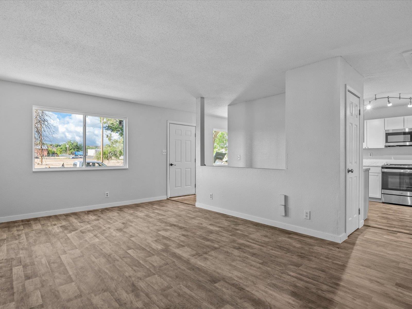 246 East Rangely Avenue Rangely, CO 81648 - Photo 2 of 21 an empty room with wooden floor and windows