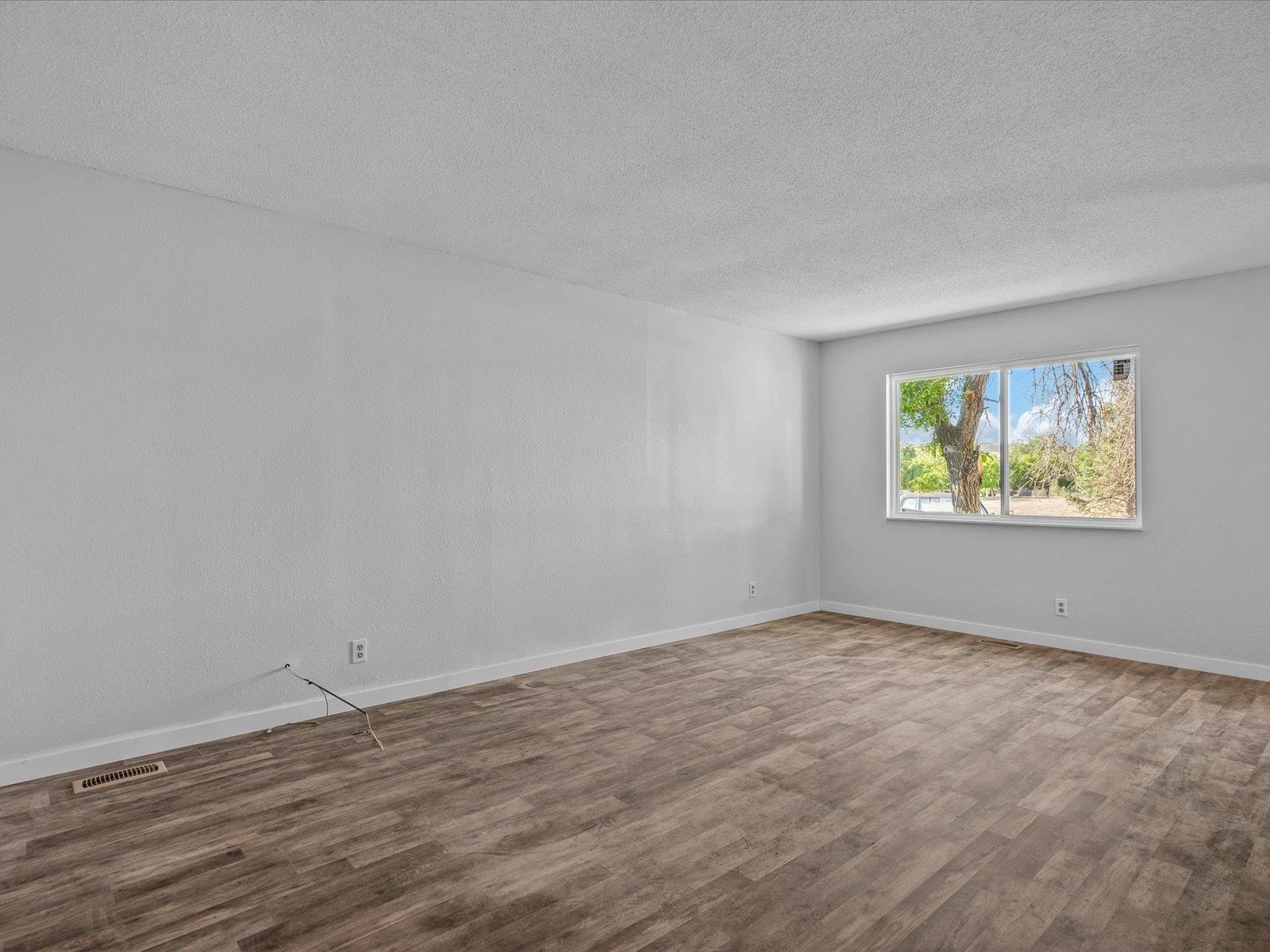 246 East Rangely Avenue Rangely, CO 81648 - Photo 3 of 21 an empty room with wooden floor and windows