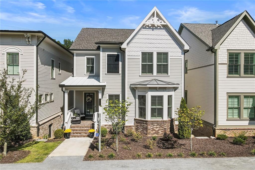 a view of a white house with large windows and a small yard