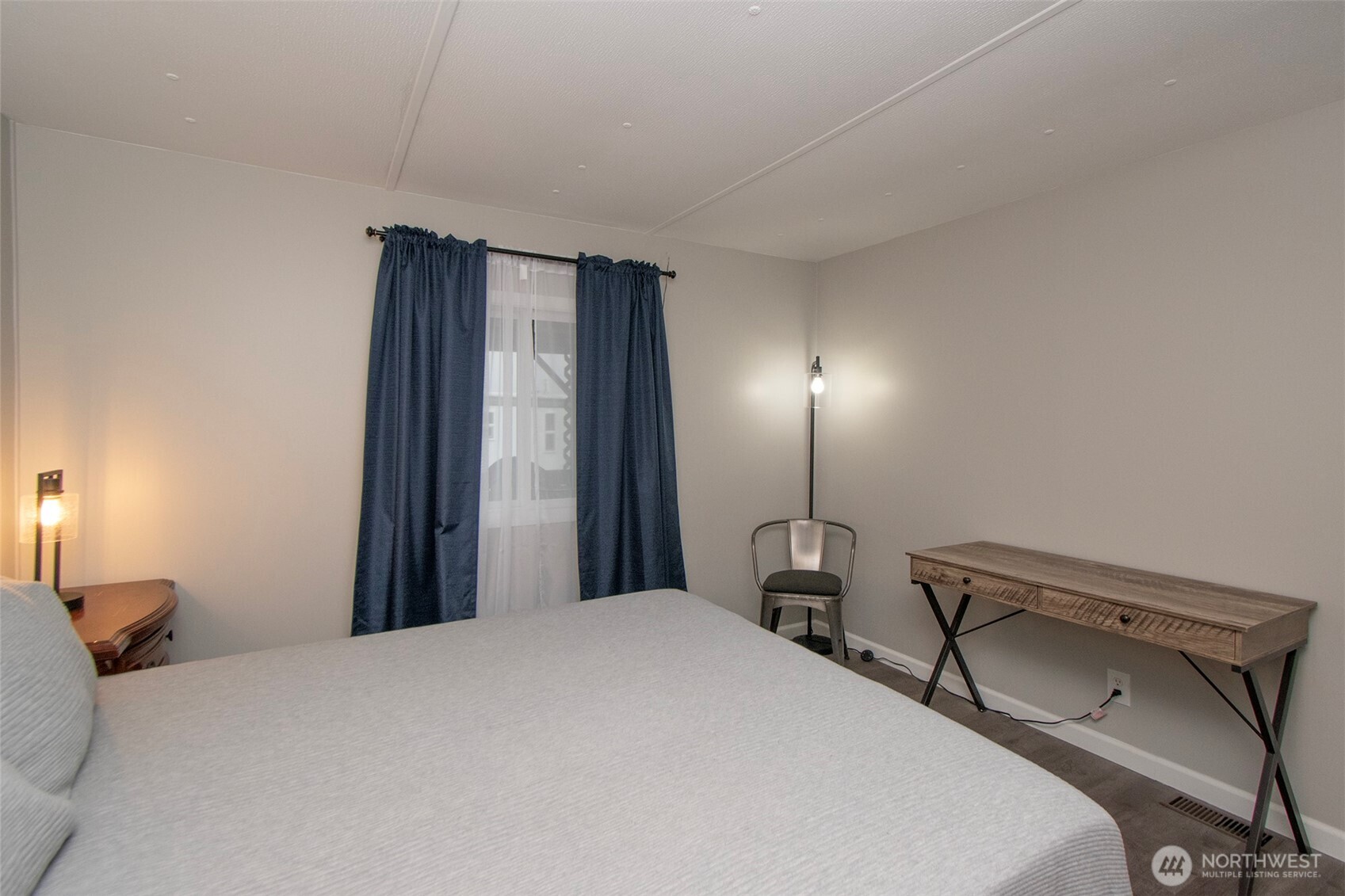 491 Mill Road, Unit 30 Sequim, WA 98382 - Photo 20 of 39 a bedroom with a bed and a lamp