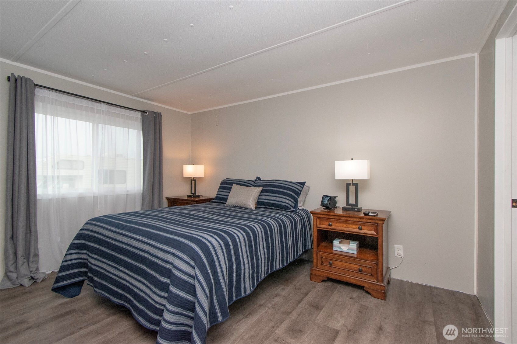 491 Mill Road, Unit 30 Sequim, WA 98382 - Photo 25 of 39 a bedroom with a bed and a lamp on table