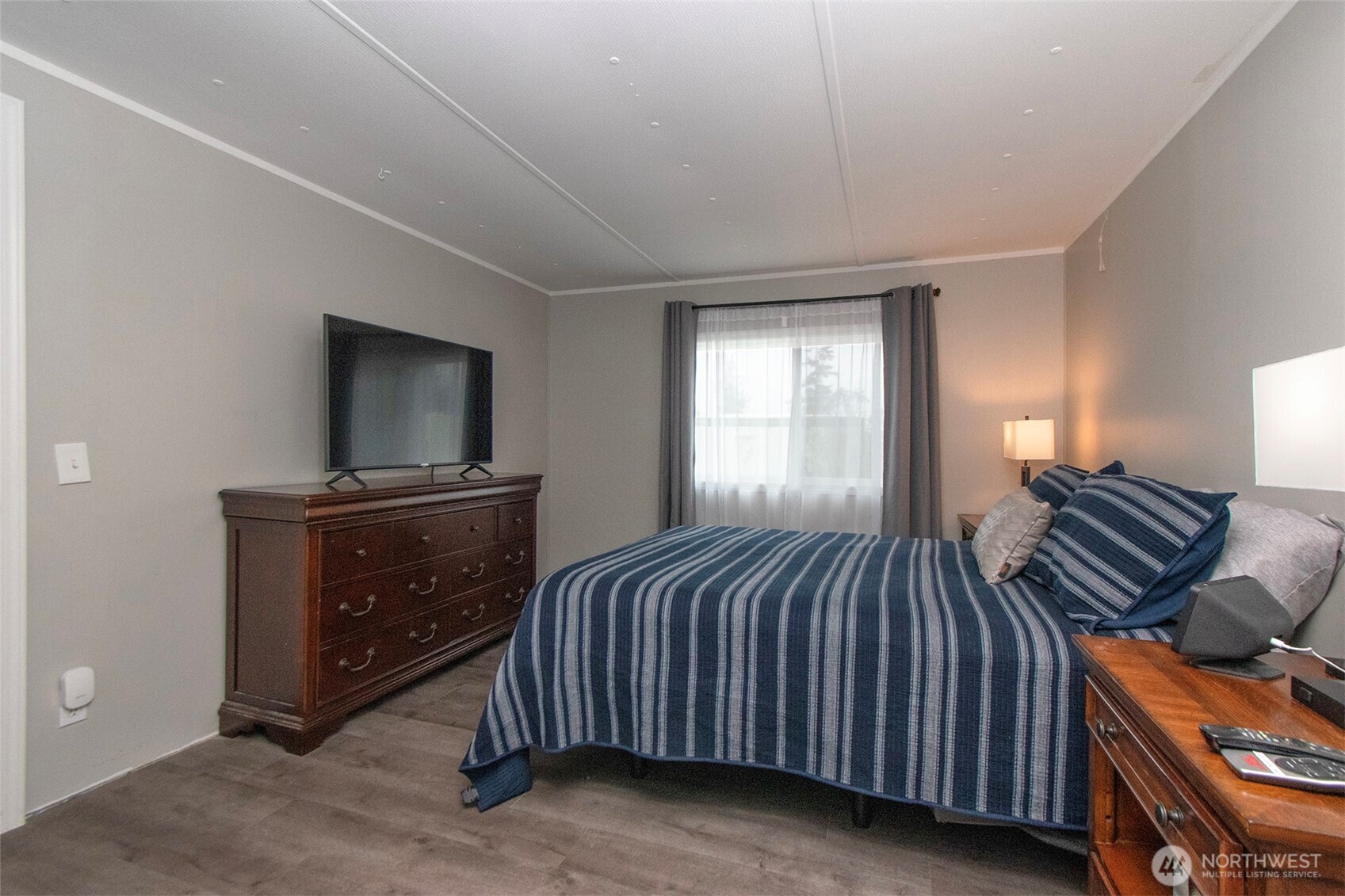 491 Mill Road, Unit 30 Sequim, WA 98382 - Photo 30 of 39 a bedroom with a bed and a tv on a dresser