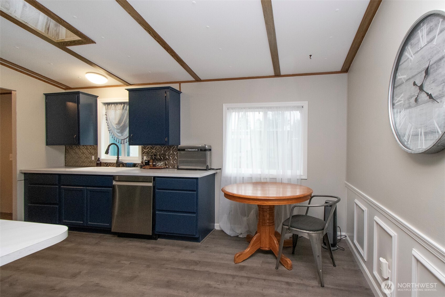 491 Mill Road, Unit 30 Sequim, WA 98382 - Photo 9 of 39 a kitchen with a table chairs a sink dishwasher window and cabinets