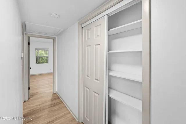 a view of a hallway with wooden floor