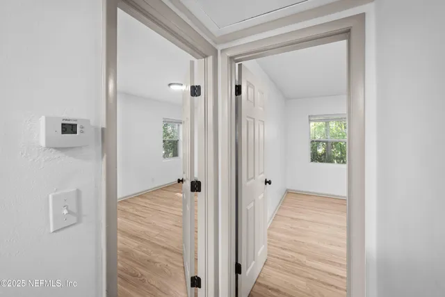 a view of a hallway with wooden floor and closet