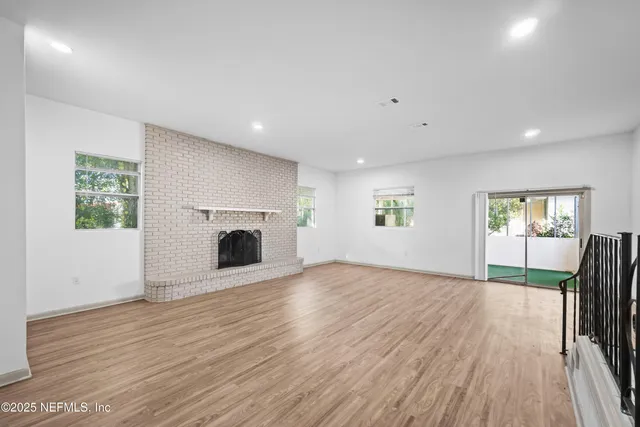 an empty room with wooden floor and fireplace