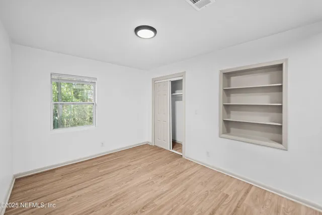 a view of empty room with wooden floor