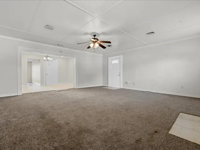 a view of a big room with ceiling fan and window
