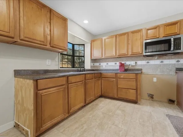 a kitchen with stainless steel appliances granite countertop a sink stove and microwave