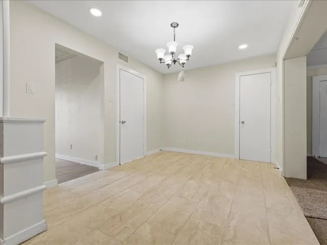 a view of an empty room with chandelier