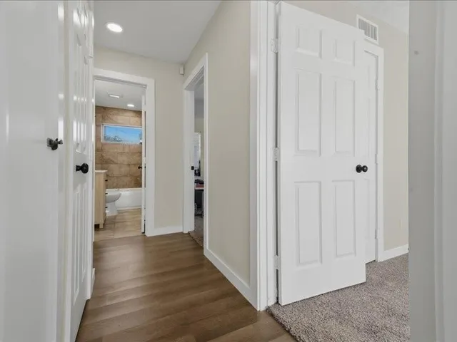 a view of a hallway with wooden floor