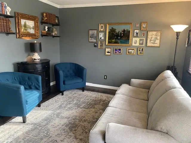 a living room with furniture and painting on the wall