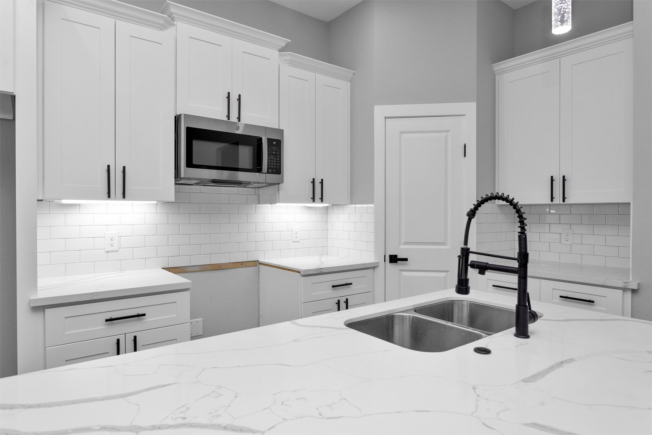 a kitchen with white cabinets a sink and a stove