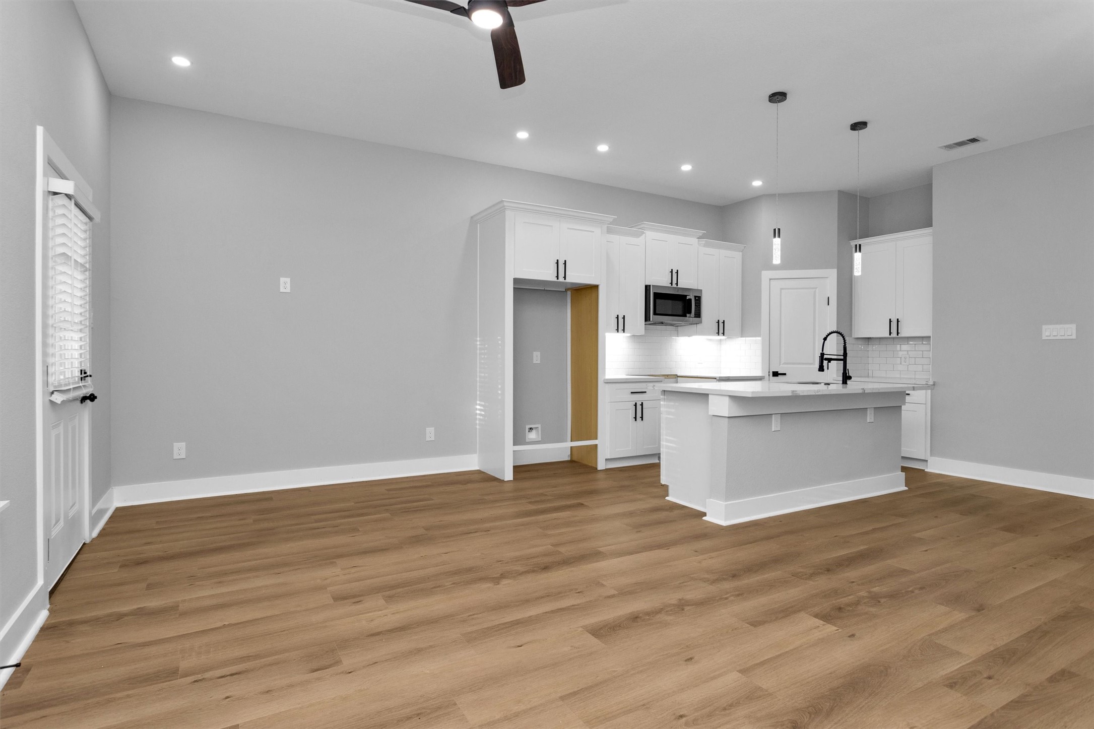 6918 Dumble Street, Unit B Houston, TX 77021 - Photo 9 of 31 a view of kitchen with kitchen island stainless steel appliances cabinets a sink and a wooden floor