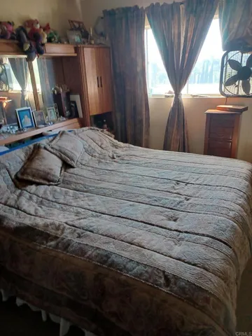 a bed sitting in a bedroom next to a window