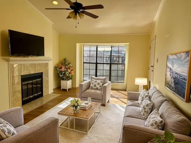 a living room with furniture a fireplace and a flat screen tv