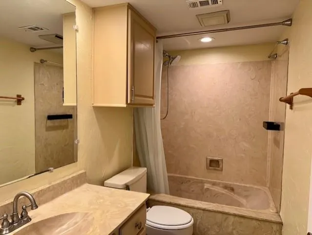 a bathroom with a granite countertop sink toilet and shower