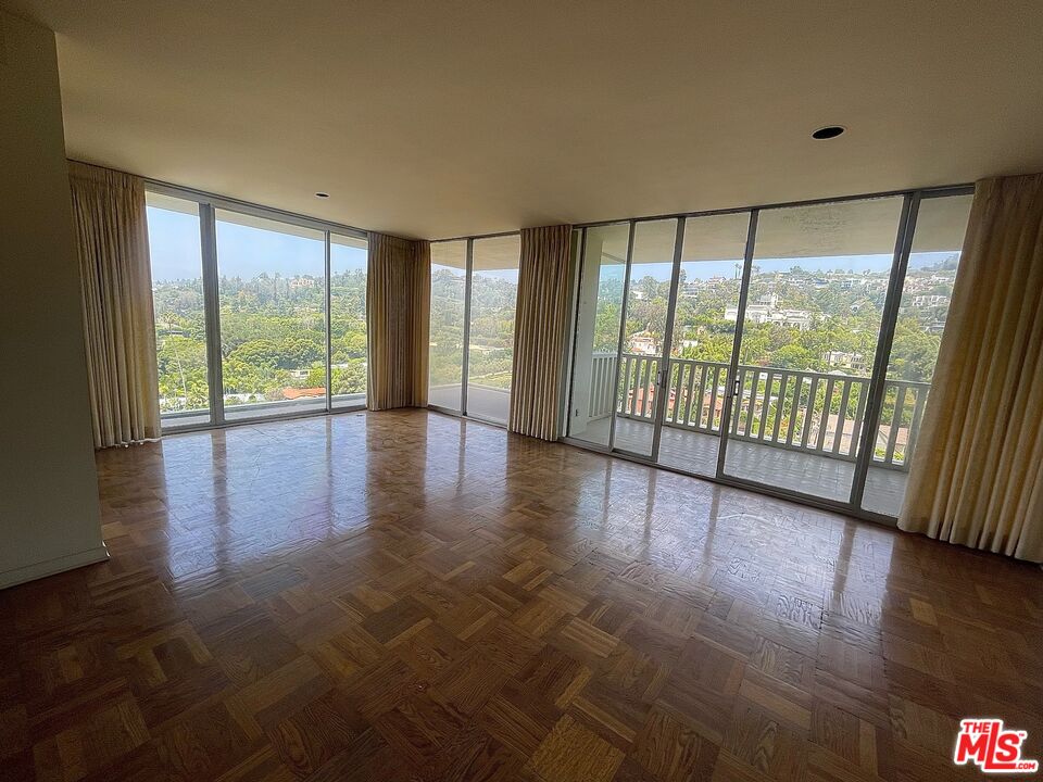 9255 Doheny Road, Unit 1401 West Hollywood, CA 90069 - Photo 2 of 5 a view of an empty room with wooden floor and a window