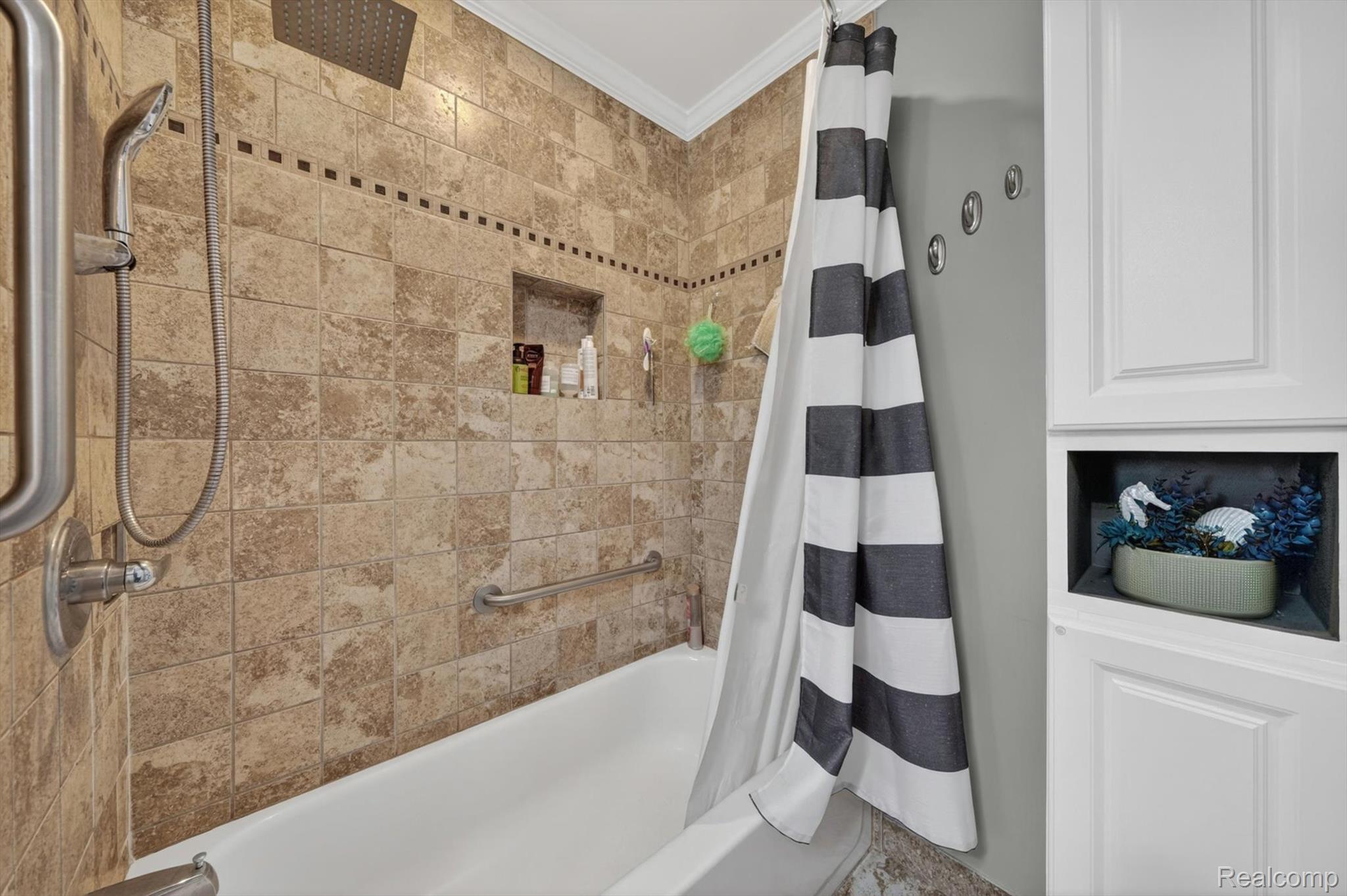 2861 John R Road Rochester, MI 48307 - Photo 24 of 54 Bathtub with tiled surround featuring a recessed niche, rain shower head, and hand-held shower fixture