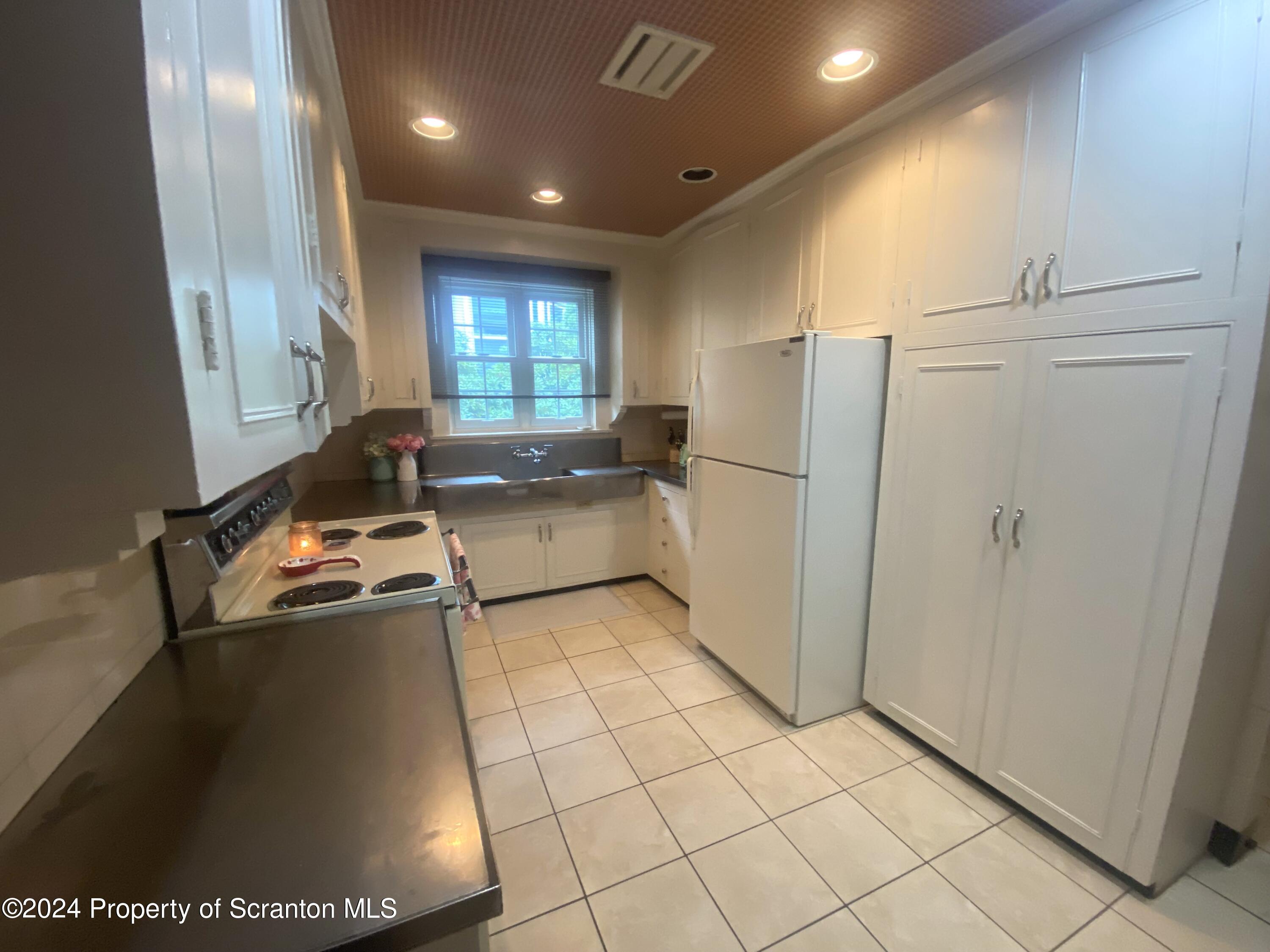 1008 Electric Street Scranton, PA 18509 - Photo 10 of 25 a kitchen with a refrigerator a stove a washer and dryer