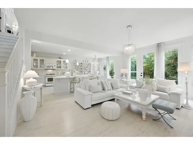 a living room with furniture a large window and a chandelier