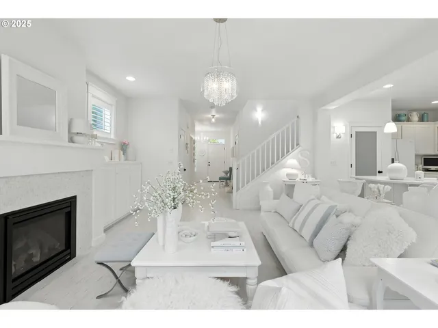 a living room with furniture a fireplace and a chandelier