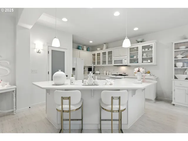 a view of kitchen island a sink and chairs