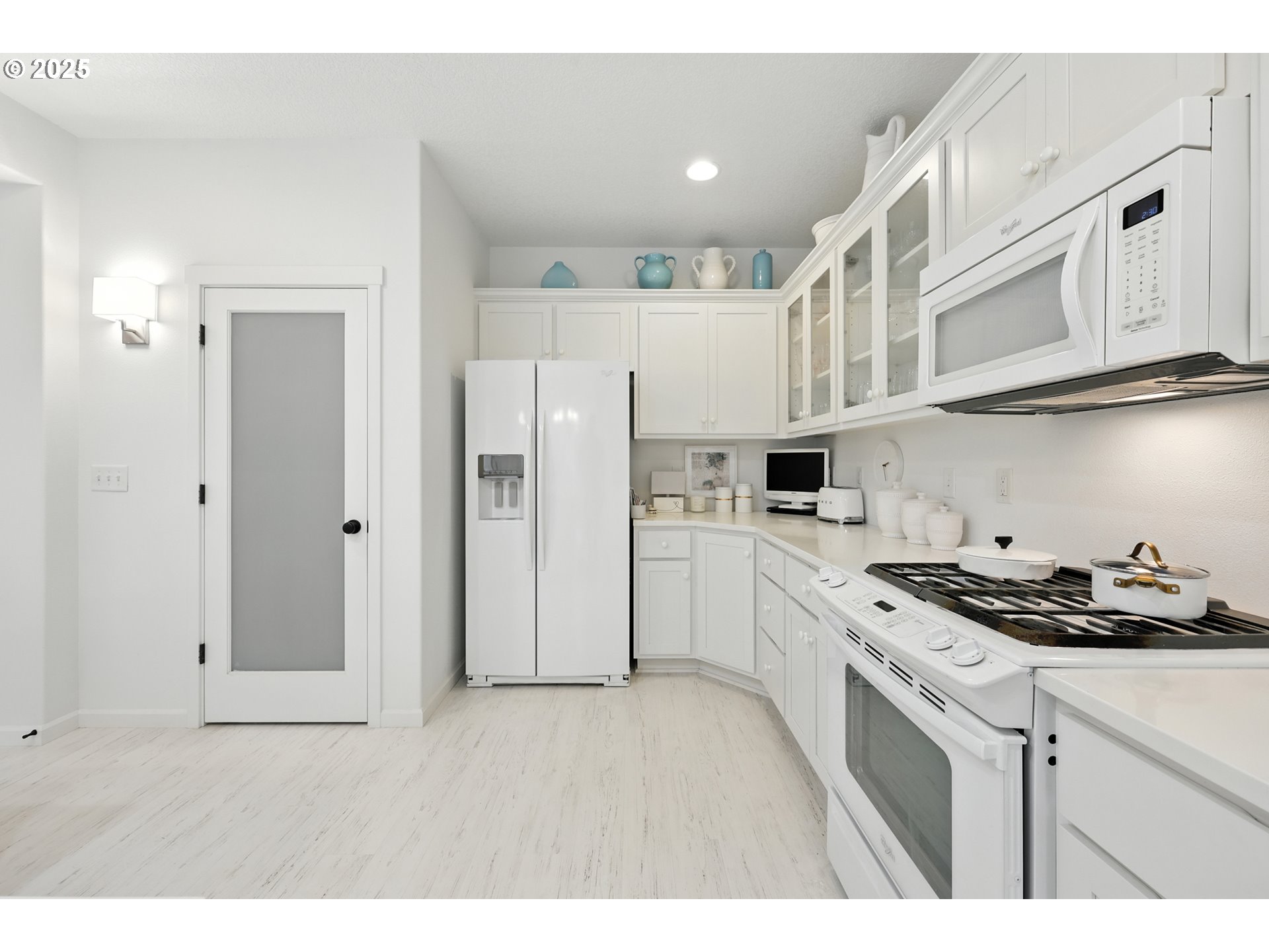 2210 South White Salmon Drive Ridgefield, WA 98642 - Photo 15 of 45 a kitchen with stainless steel appliances granite countertop a refrigerator a stove a sink and white cabinets with wooden floor