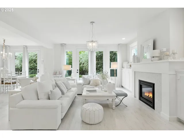 a living room with furniture a fireplace and a chandelier