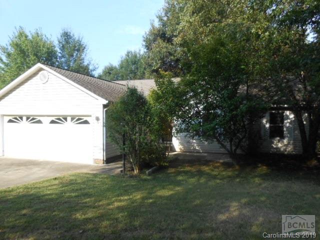a view of a house with a yard and a garage