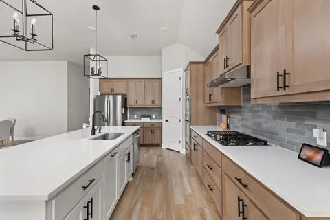 a kitchen with granite countertop white cabinets and stainless steel appliances