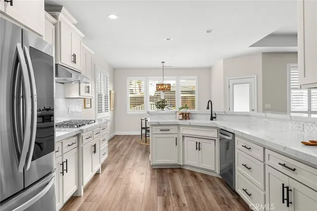 a dining room with wooden floor a chandelier a wooden table and chairs