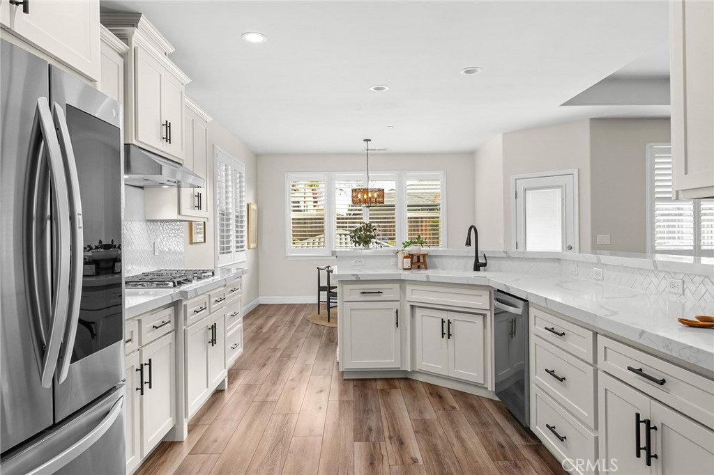 1971 Potter Road Chico, CA 95928 - Photo 20 of 59 a large kitchen with stainless steel appliances a stove a sink dishwasher a refrigerator white cabinets and wooden floor