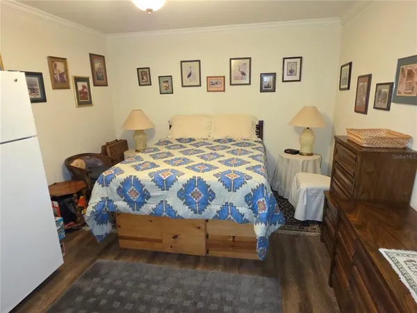 a bedroom with a bed and wooden floor