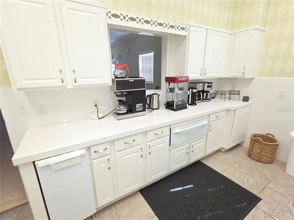a kitchen with white cabinets and white appliances