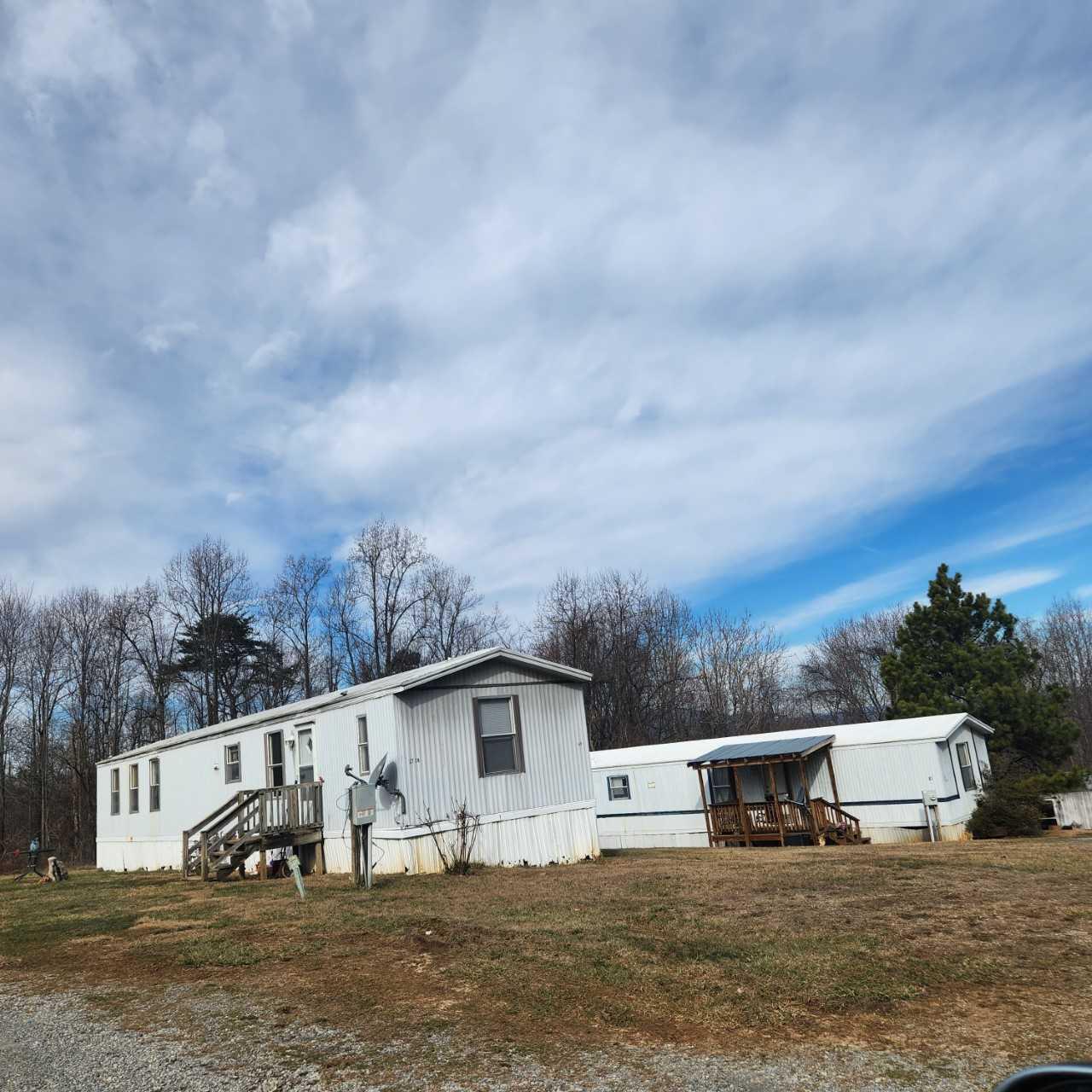 1735 Doe Run Road Rocky Mount, VA 24151 - Photo 5 of 6 a view of a white house with a big yard and large trees