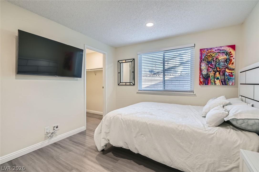 3665 Bronco Road Las Vegas, NV 89103 - Photo 21 of 28 A comfortable bedroom with sleek wood flooring and a convenient walk-in closet.