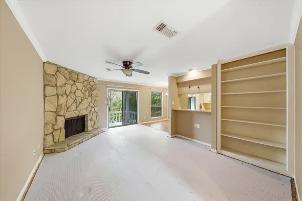 a view of an empty room with a fireplace and a window