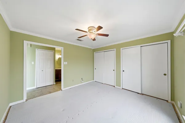 a view of an empty room with a ceiling fan and a window
