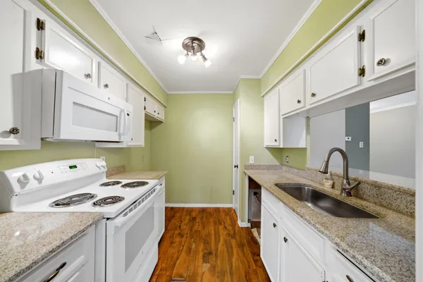 a kitchen with a sink a stove and cabinets