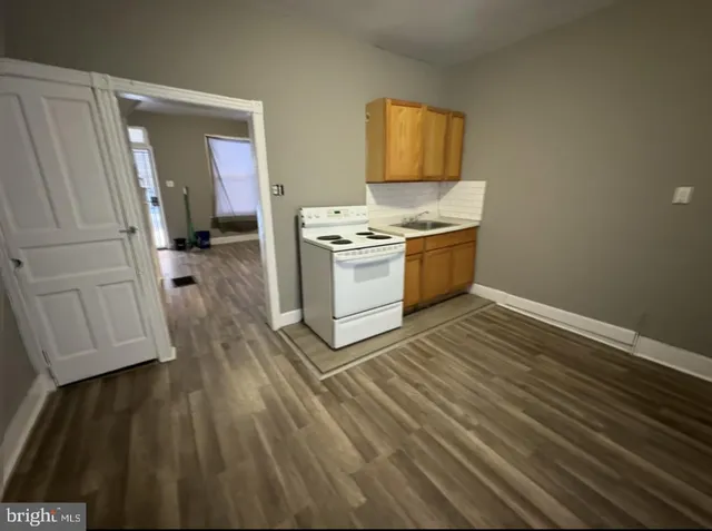 a kitchen with wooden floors and white appliances